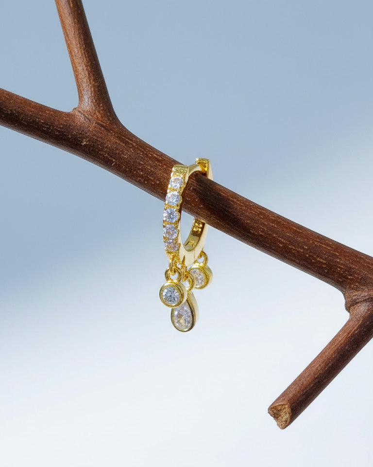 CZ huggie hoop with three dangling stones in bezel setting.