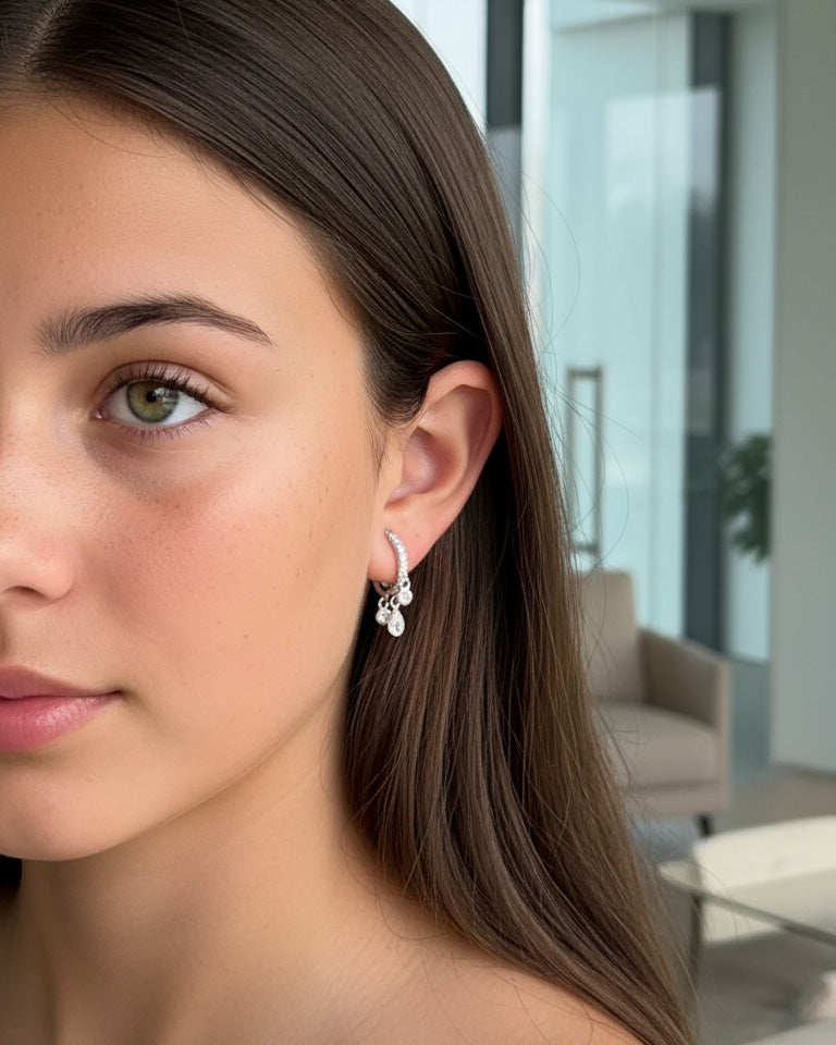 CZ huggie hoop with three dangling stones in bezel setting.