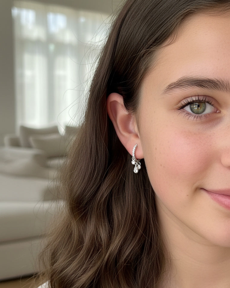 CZ huggie hoop with three dangling stones in bezel setting.