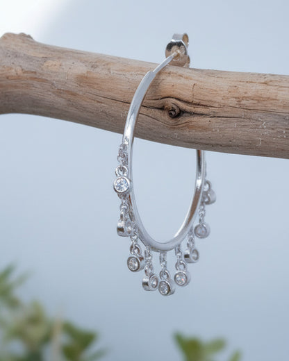 Plain hoops with dangling CZ in bezel setting.