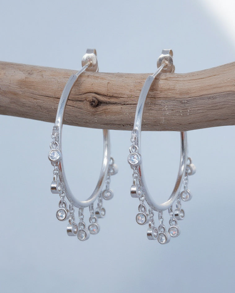 Plain hoops with dangling CZ in bezel setting.