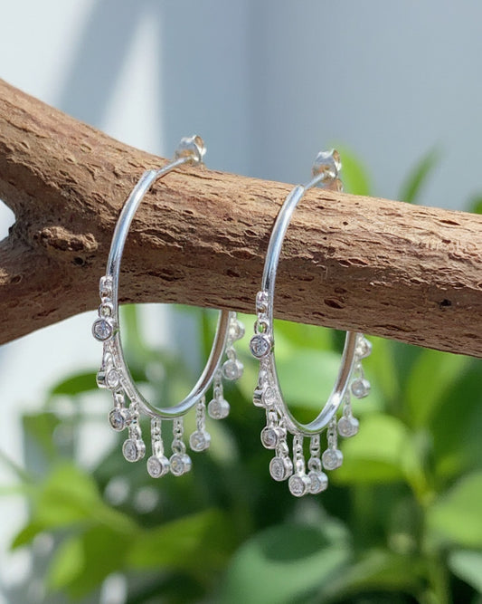 Plain hoops with dangling CZ in bezel setting.