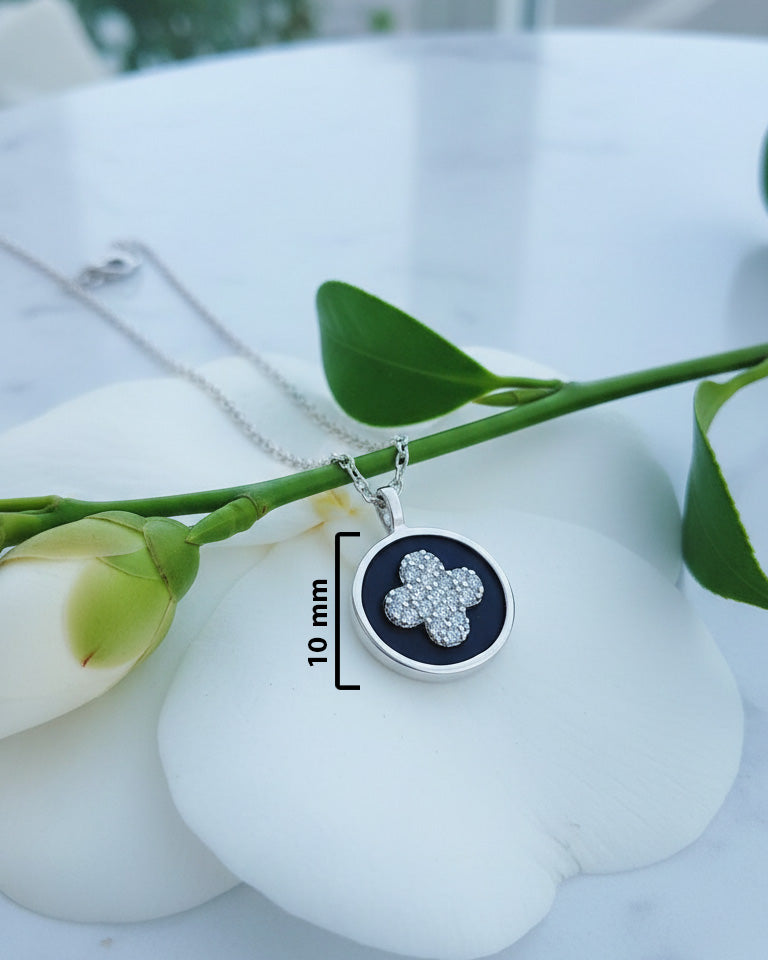 four clover flower CZ in a black enamel round shape necklace.