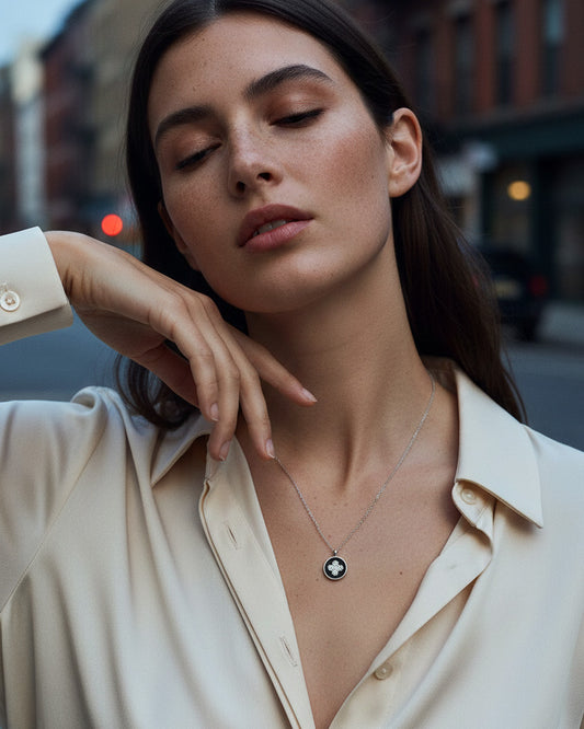 four clover flower CZ in a black enamel round shape necklace.