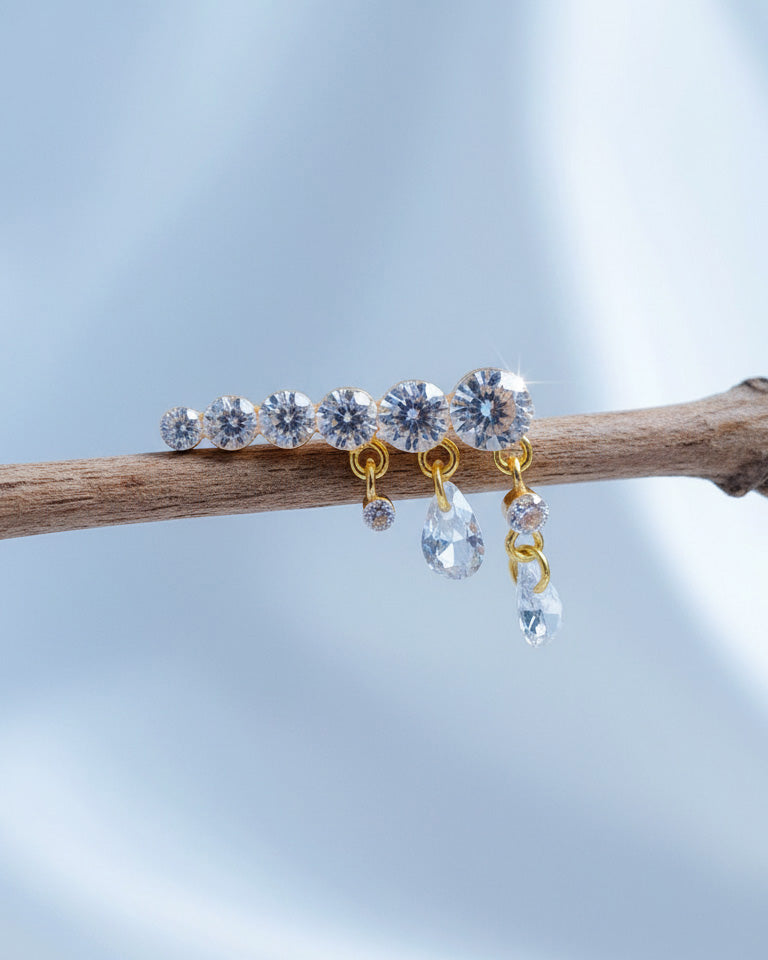 Round graduated CZ bar with dangling pierced pear shapes.