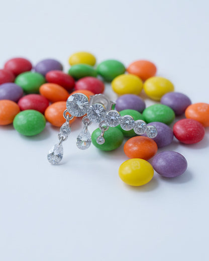 Round graduated CZ bar with dangling pierced pear shapes.