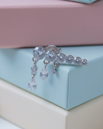 Round graduated CZ bar with dangling pierced pear shapes.