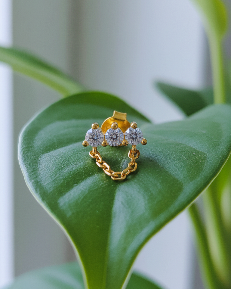 three stones bar earring with dangling chain.