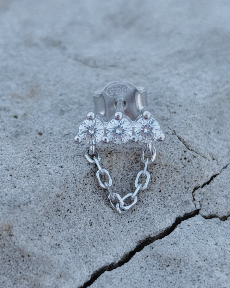 three stones bar earring with dangling chain.