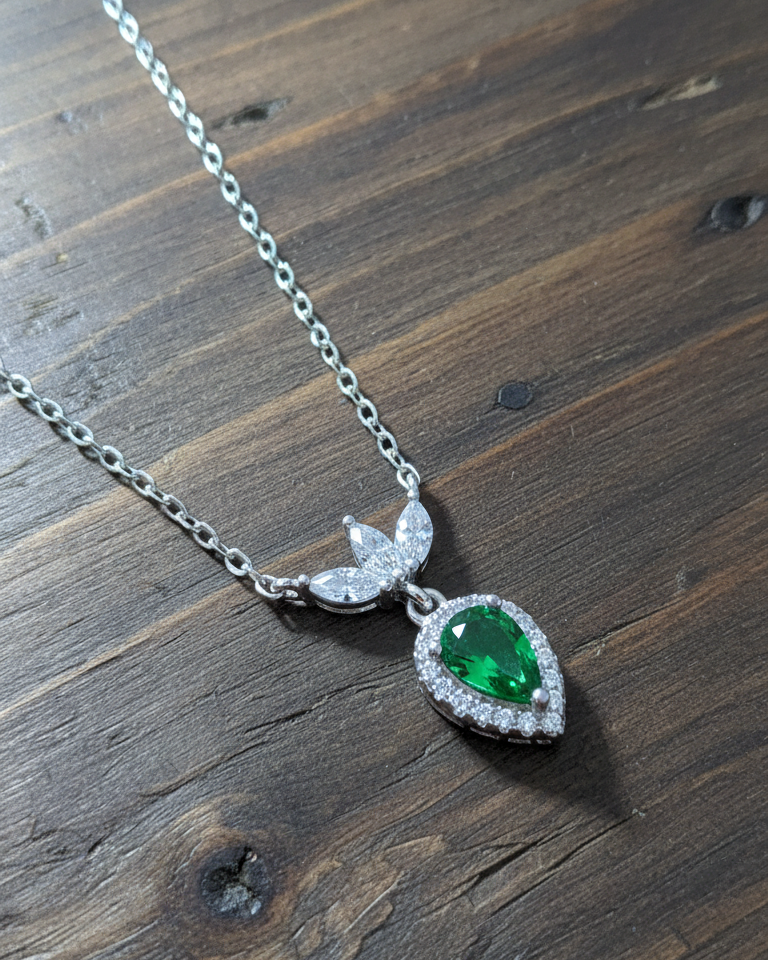 Emerald color pear shape with three white marquise shapes necklace.