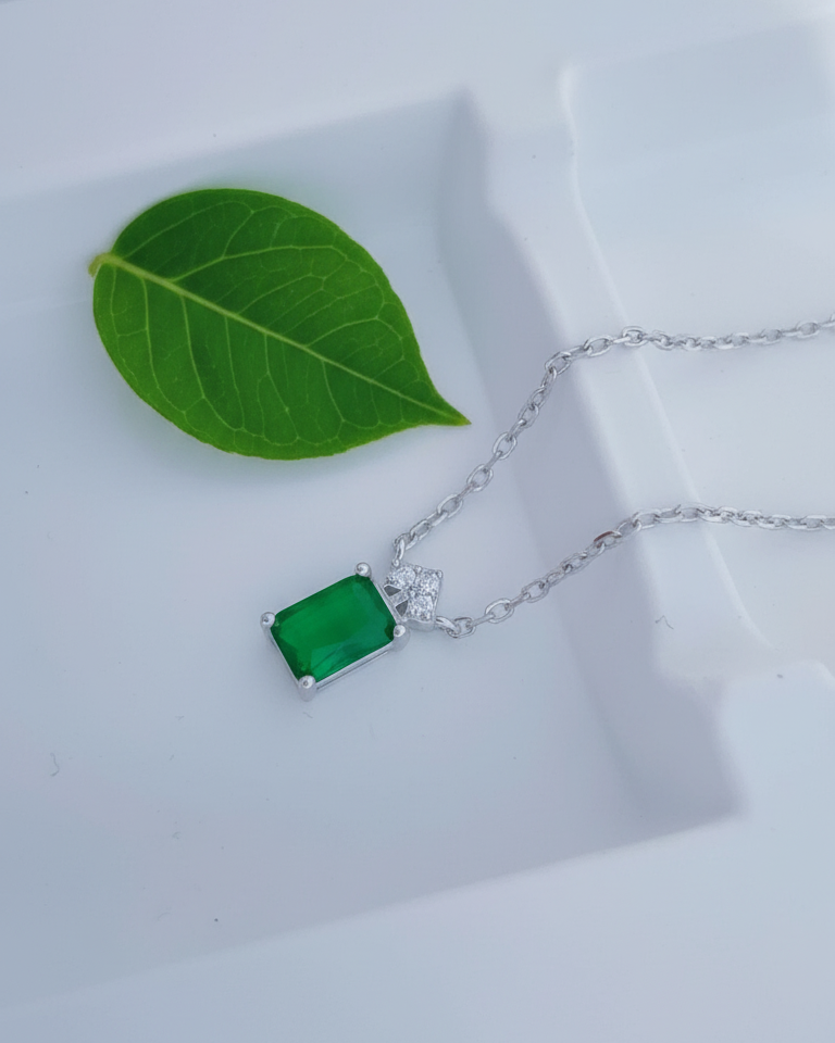 emerlad cut green CZ stone with three white stones neckace.