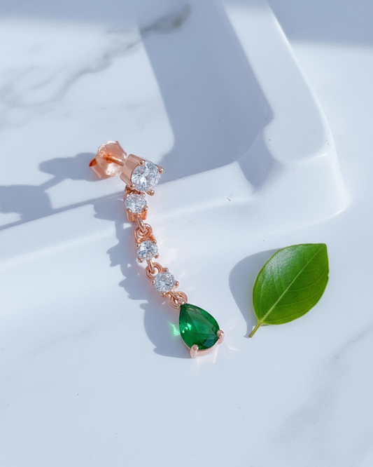 white CZ line ending with emerald color pear shape stud earring.