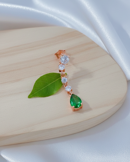 white CZ line ending with emerald color pear shape stud earring.