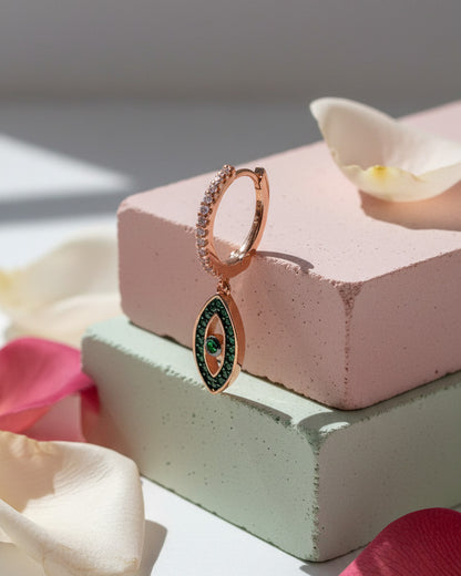 rosegold huggie hoop with dangling eye shape.