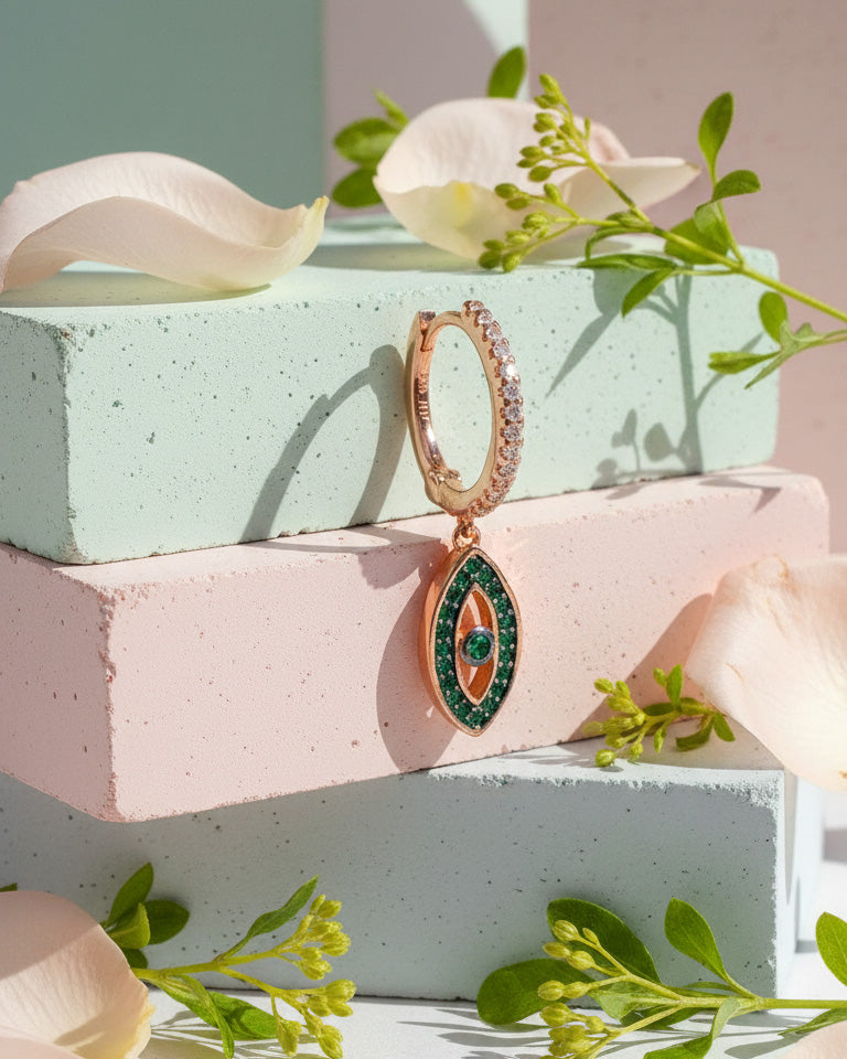 rosegold huggie hoop with dangling eye shape.