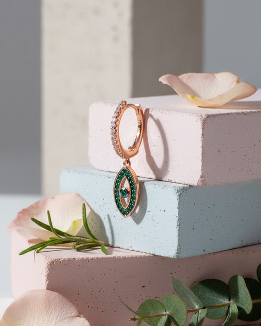 rosegold huggie hoop with dangling eye shape.