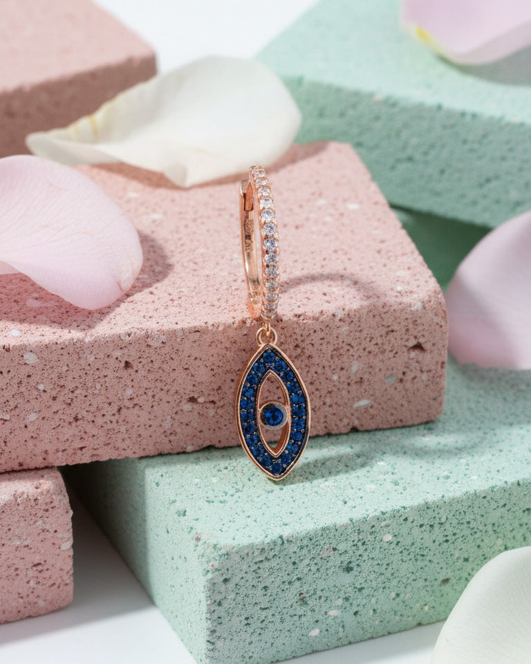 rosegold huggie hoop with dangling eye shape.