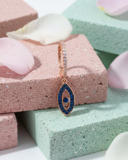 rosegold huggie hoop with dangling eye shape.