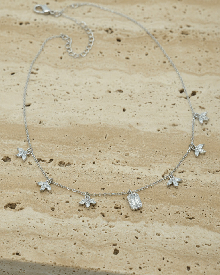 delicate necklace of dangling lotus shape and emerald cut stone.