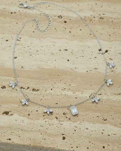 delicate necklace of dangling lotus shape and emerald cut stone.