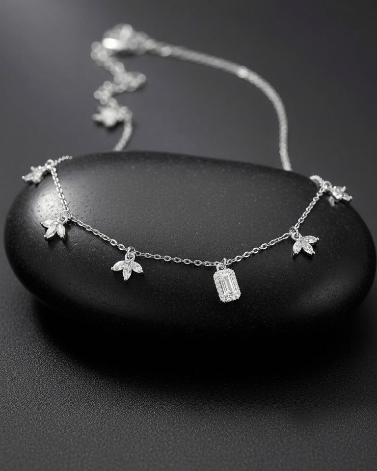 delicate necklace of dangling lotus shape and emerald cut stone.