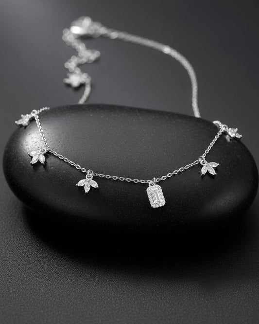 delicate necklace of dangling lotus shape and emerald cut stone.
