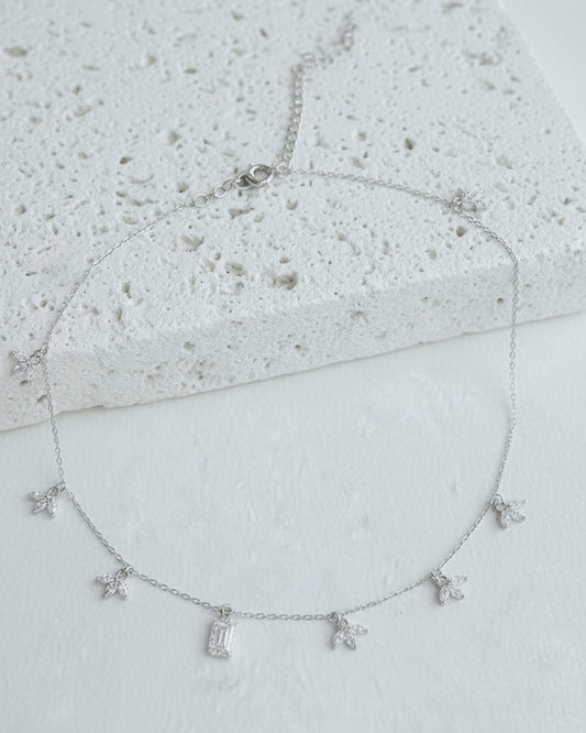 delicate necklace of dangling lotus shape and emerald cut stone.