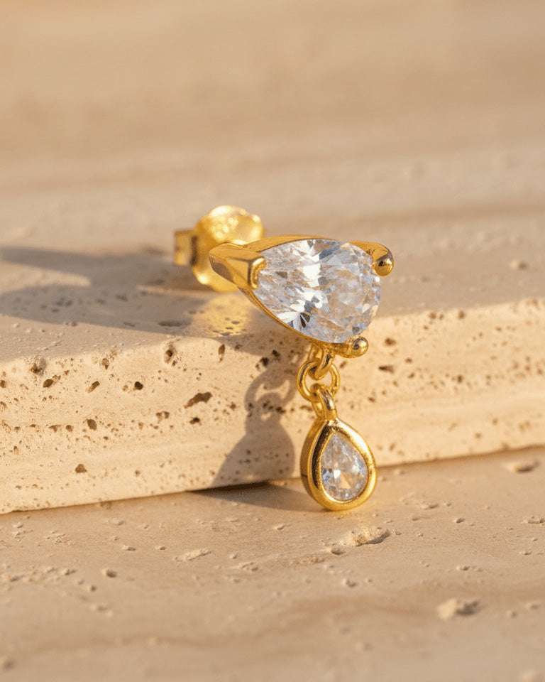 pear shape in prong setting with a dangling smaller pear in bezel setting stud earring.