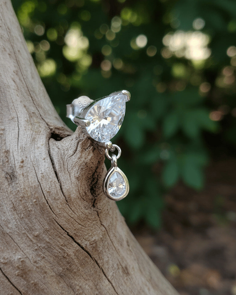 pear shape in prong setting with a dangling smaller pear in bezel setting stud earring.