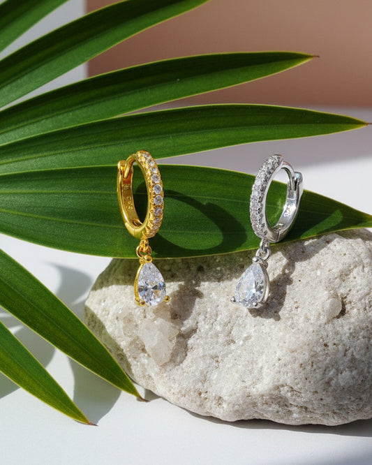 Huggie hoop earring with dangling CZ pear shape.