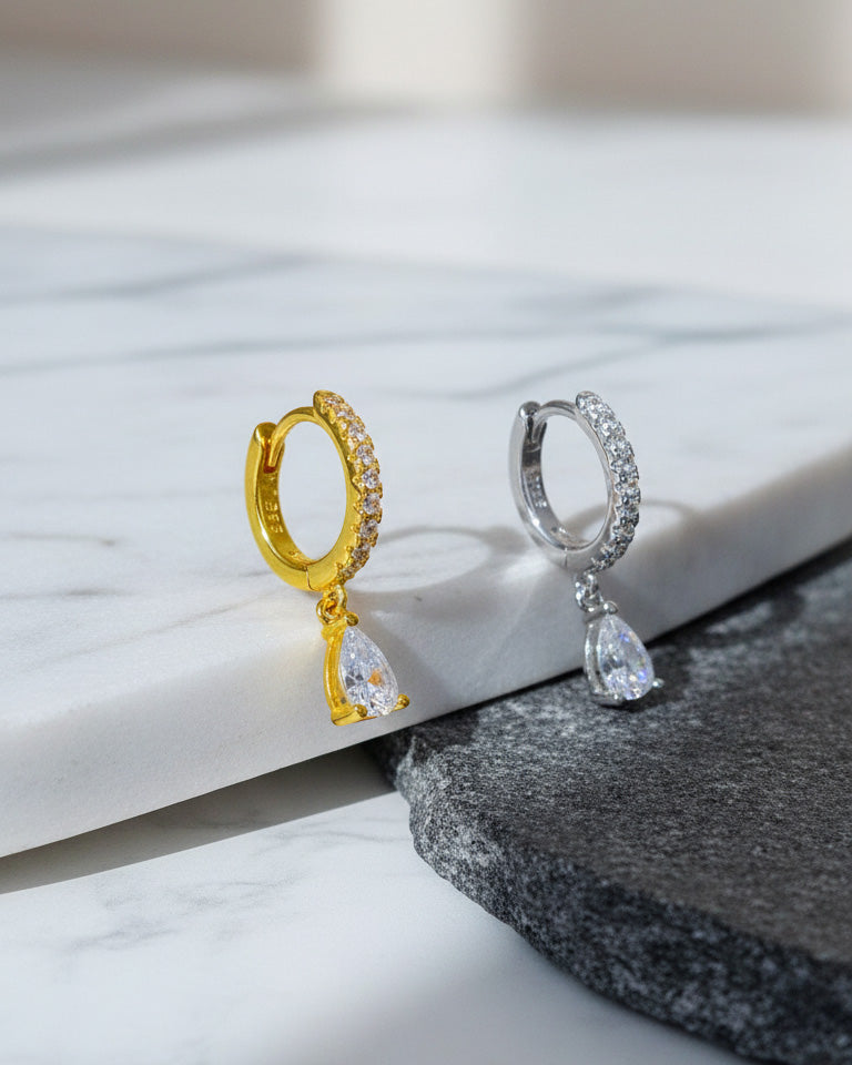 Huggie hoop earring with dangling CZ pear shape.