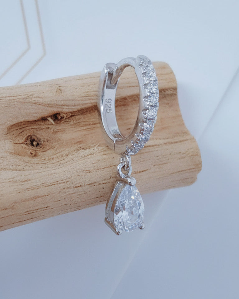 Huggie hoop earring with dangling CZ pear shape.