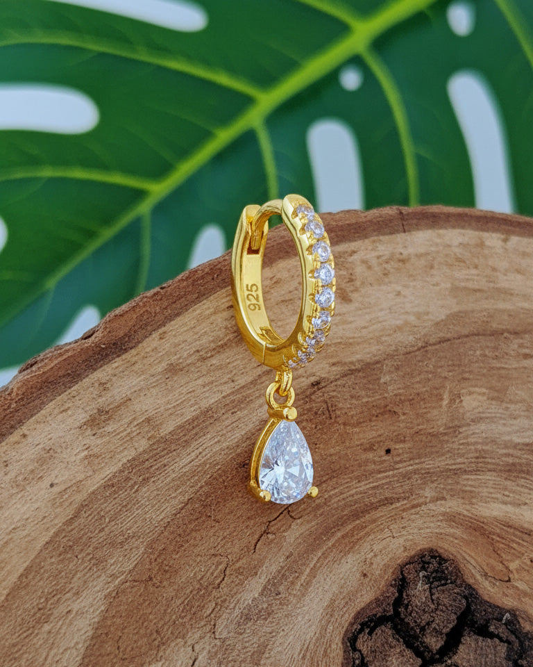 Huggie hoop earring with dangling CZ pear shape.