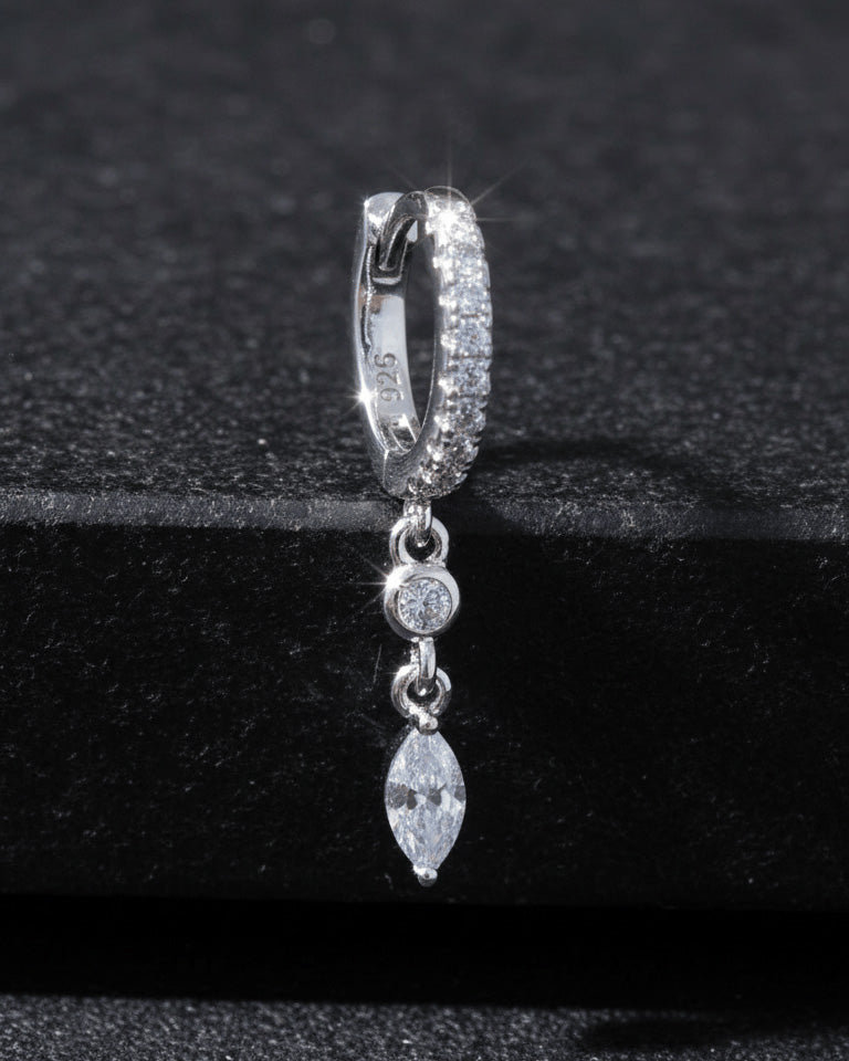 CZ huggie hoop with dangling white and emerald color stones.