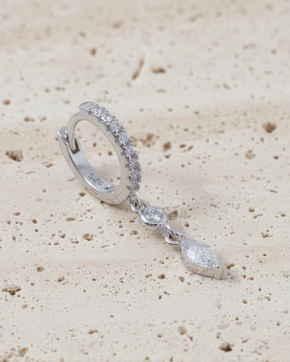 CZ huggie hoop with dangling white and emerald color stones.
