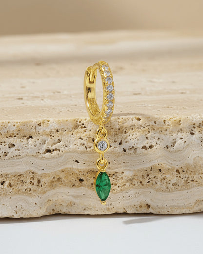 CZ huggie hoop with dangling white and emerald color stones.
