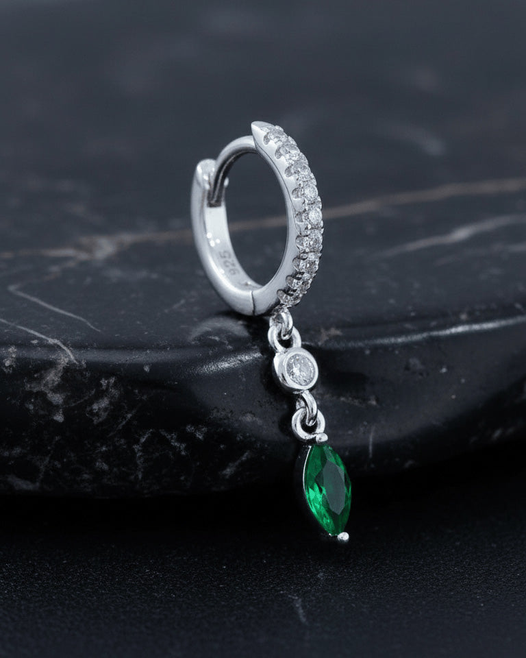 CZ huggie hoop with dangling white and emerald color stones.