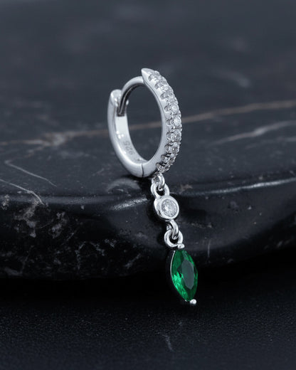 CZ huggie hoop with dangling white and emerald color stones.