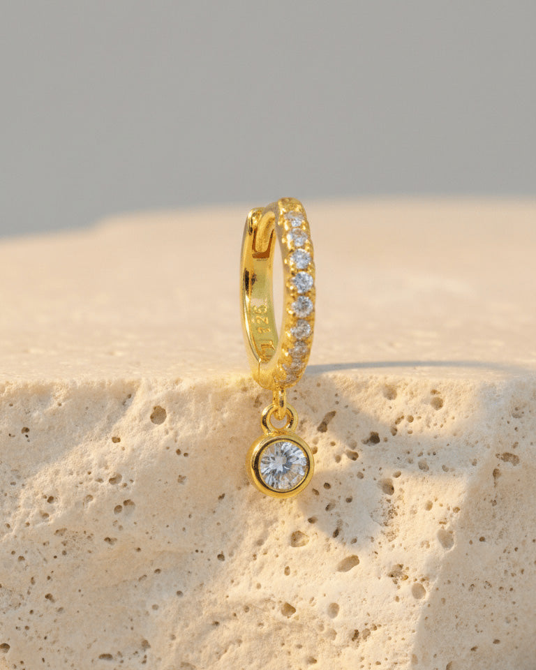 8 mm CZ huggie hoop earring with dangling round stone in bezel setting.