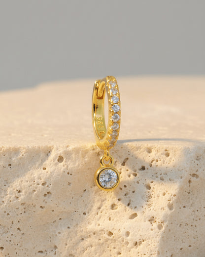 8 mm CZ huggie hoop earring with dangling round stone in bezel setting.