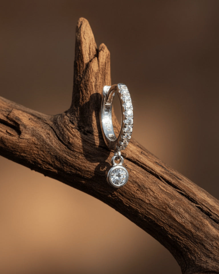 8 mm CZ huggie hoop earring with dangling round stone in bezel setting.