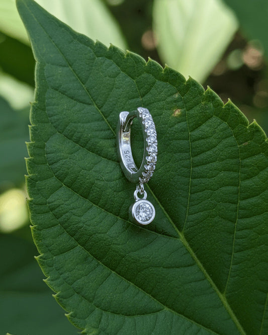 8 mm CZ huggie hoop earring with dangling round stone in bezel setting.