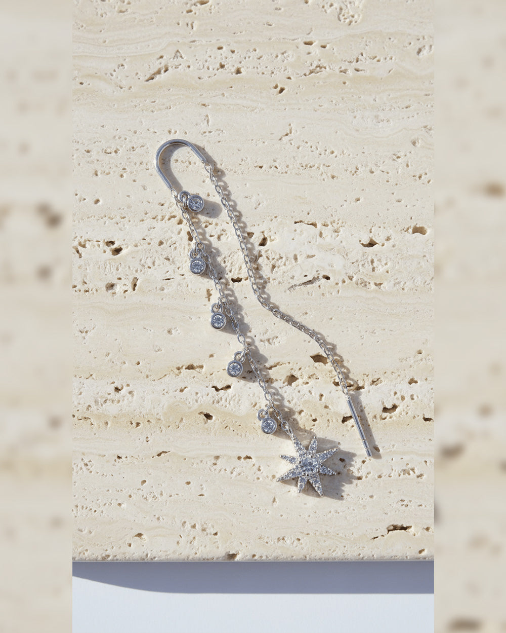 threader star earring with dangling CZ in bezel setting.