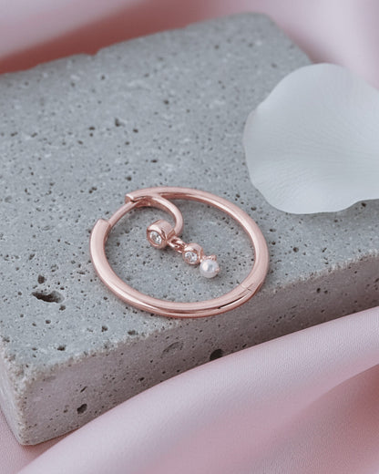 rosegold hoop earring with dangling CZ and pearl.
