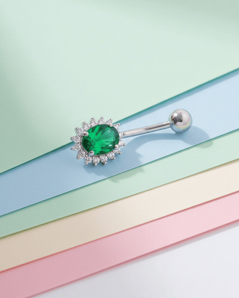 Oval emerald and sapphire color CZ in halo setting belly piercing.