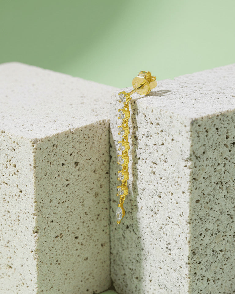 line of delicate links with round CZ ends with a marquise shape stud earring.