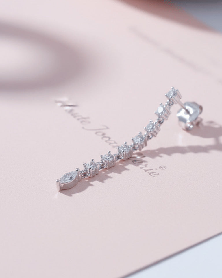 line of delicate links with round CZ ends with a marquise shape stud earring.